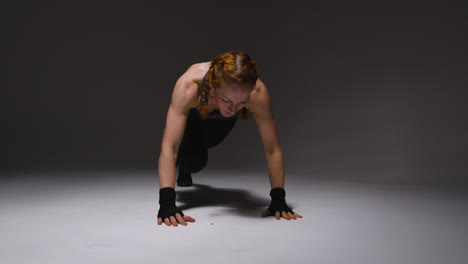 Foto-De-Estudio-De-Una-Mujer-Madura-Vistiendo-Ropa-De-Gimnasio-Haciendo-Ejercicio-De-Alpinista